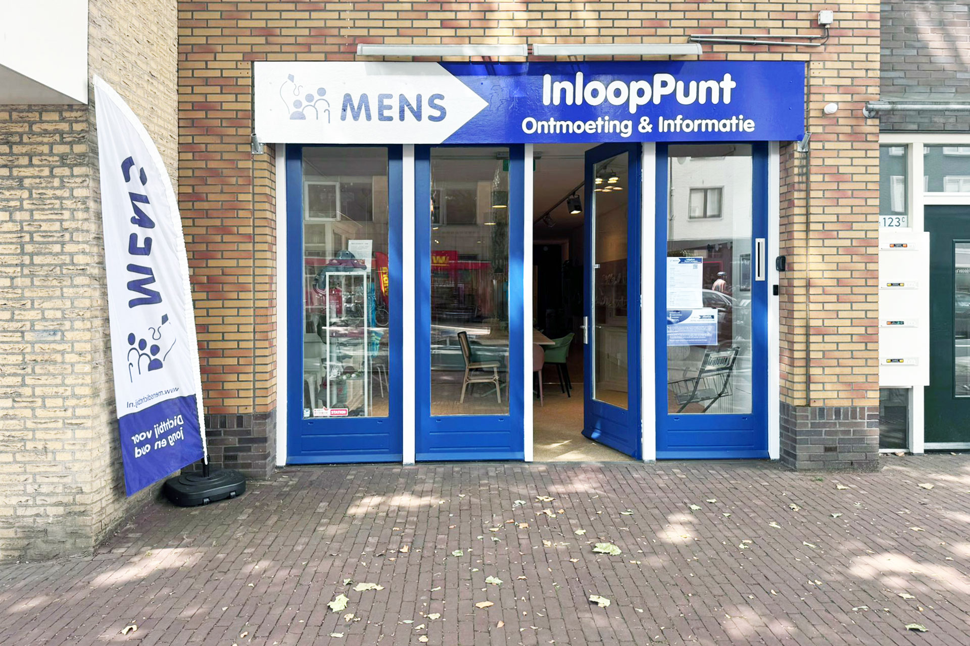 Locatie de Bilt. Een ingang met blauwe openstaande deuren met de tekst; "inlooppunt".
