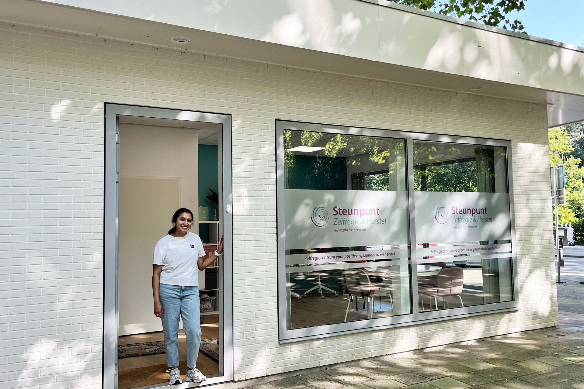 Kantoor Zeist, met een medewerkster die je in de openstaande buitendeur verwelkomt.